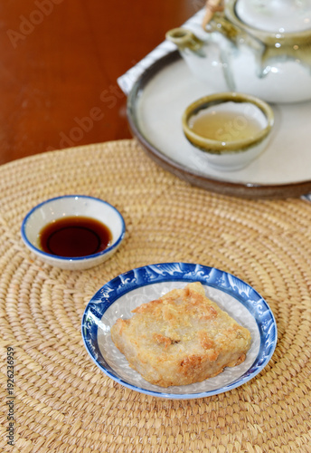 Delicious Chinese radish cake in a plate on wooden table background