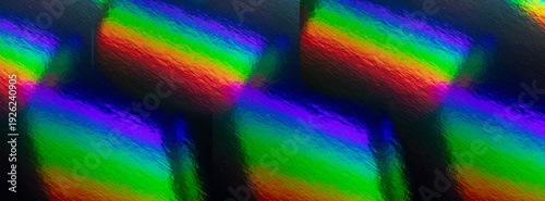 A vivid, abstract rainbow gradient across a textured surface. Rich greens, bl...