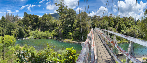 Wallpaper Mural Red Hut Bridge over Tongariro River, New Zealand. Aging swing bridge, due for replacement. Panoramic view. Part of Tongariro River Trail. Access to trout fishing pools. Mt Pihanga in distance. Torontodigital.ca