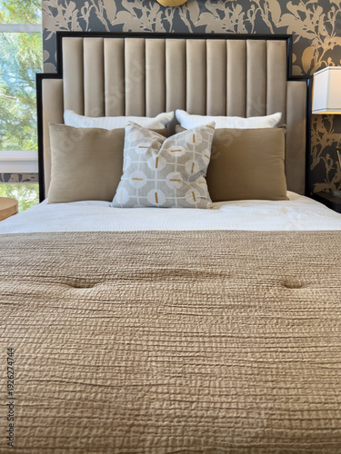 Upholstered Bed with Tan Bedding Accents
