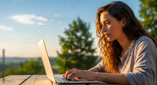 Woman working on laptop outdoors in nature