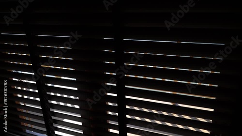 close up of blinds in the dark. abstract background.this blinds is brown on the yellow background. perspective angle of the venetian or wooden blinds.