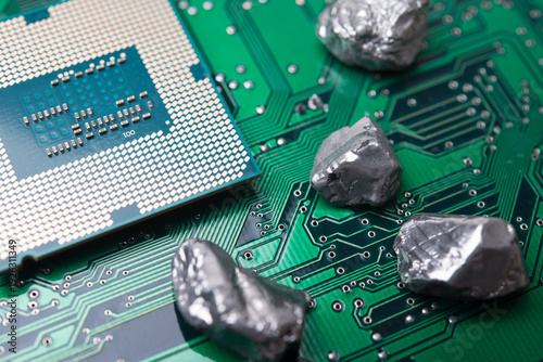 Mineral rare earth element and CPU on green electronic circuit board background. US vs China chip war, tech war, semiconductor industry concept. China curbs on exports of rare earth element to US.