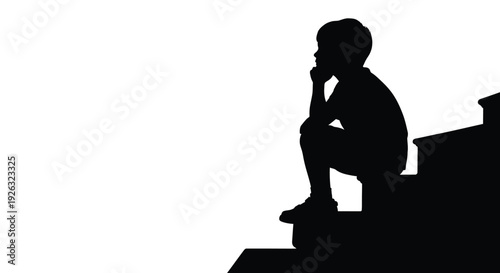 Silhouette of a thoughtful boy sitting on stairs with hand on his chin