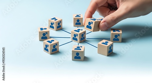 Hand placing a wooden block with blue people icons into a network  business concept
