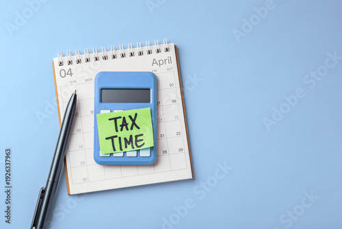 Tax time concept, sticky note with tax time word on calculator with calendar and pen on light blue background, top view