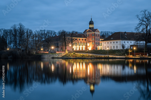 Castle of Eutin at blue hour on autumn evening with reflections on water, Schleswig-Holstein, Germany