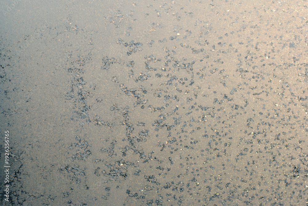 Fototapeta premium Frost on glass with warm light winter abstract background