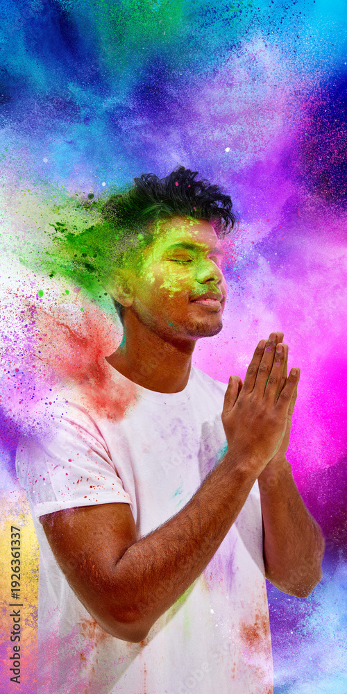 Fototapeta premium Young man praying with colorful powder explosion background. Concept of Holi spiritual tradition, mindful celebration moment, cultural heritage symbolism and vibrant creative backdrop.