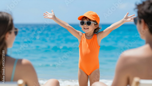 Joyful Little Girl In Orange Swimwear Enjoying A Sunny Beach Day With Family In The Background