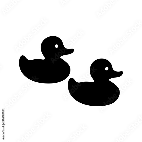 two simple black silhouette illustrations of toy rubber ducks facing right