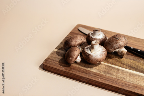 Fresh Brown Mushrooms on a Wooden Cutting Board with a Knife