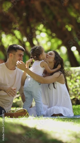 Happy family having a picnic and hugging on the blanket