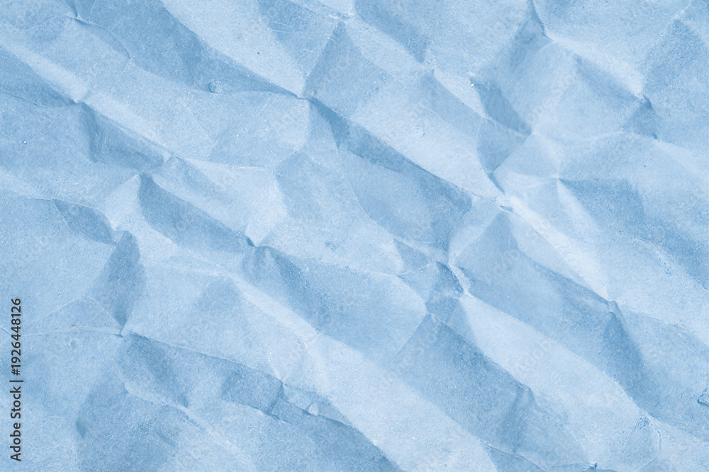 Obraz premium Soft blue crumpled paper texture with natural folds and subtle shadows. Minimal abstract background with gentle light and delicate creases. Calm pastel tone perfect for design, branding, packaging moc