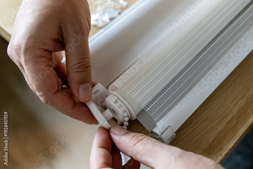 Cuadro en lienzo Hands installing roller blinds on windows in details.