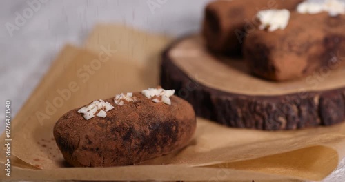 a black potato cake lies on a board and paper, a sweet classic cake made from butter and a large amount of cocoa mixed with sponge cake and cognac