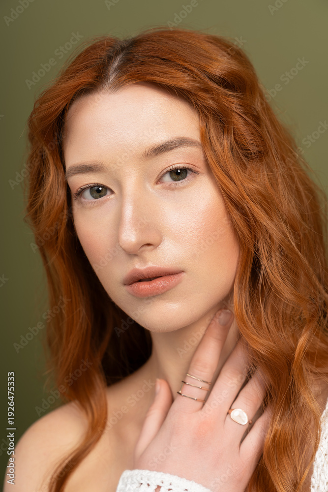 Naklejka premium Redhead woman in stylish spring attire shines in studio setting