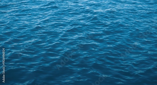 Peaceful blue water texture with gentle wave ripples providing a calm and serene backdrop