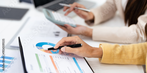 Two colleagues engaged in business analytics,  over financial charts. Colleagues Collaborating on Business Analytics.