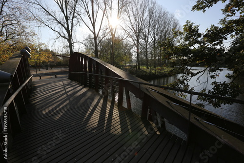 wooden footbridge over canal in autumn park brugge belgium