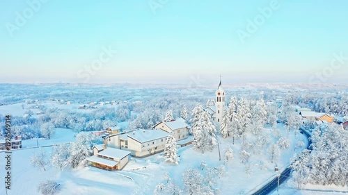 Winter church above snowy village landscape