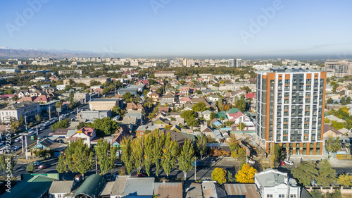 Foto Aerial panorama of Bishkek, Kyrgyzstan with Soviet-era blocks, private houses, and distant smokestacks illustrating Central Asian urban growth and mixed development