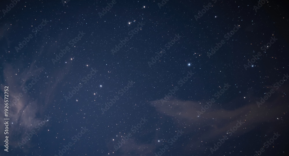 Fototapeta premium Star filled night sky close up with lightly drifting clouds