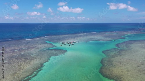 Amazing view of dozens of small boats in the natural pools among the coral reefs of Milagres beach near Maceio city, coast of Brazil 