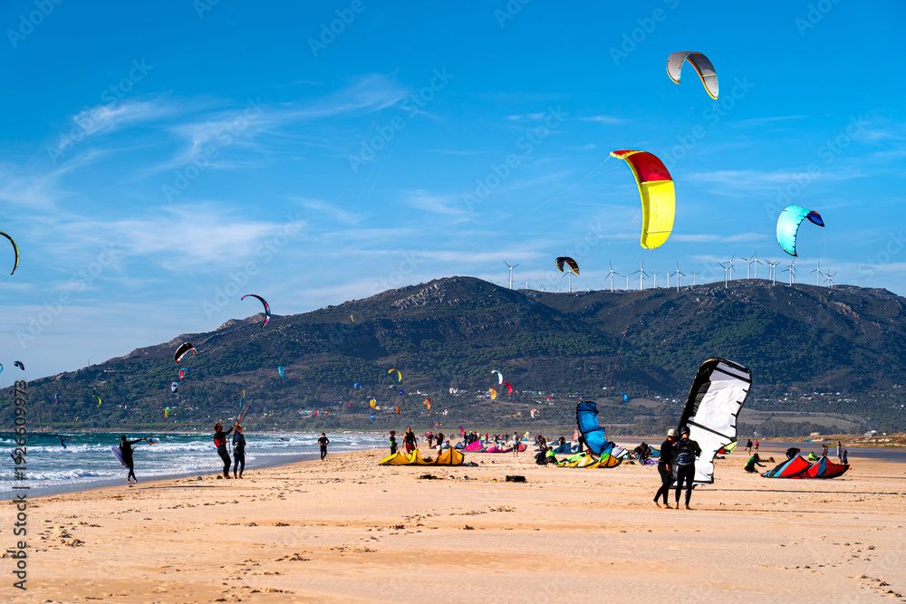 Obraz premium Kitesurfers and tourists on beach in Tarifa, active holidays in Spain, Andalusia.