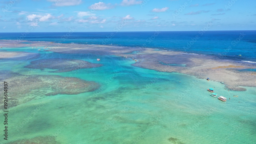 Fototapeta premium Wonderful view of white sand beach with turquoise waters and coral reefs in Milagres route near Maceio city, Alagoas State, Brazil