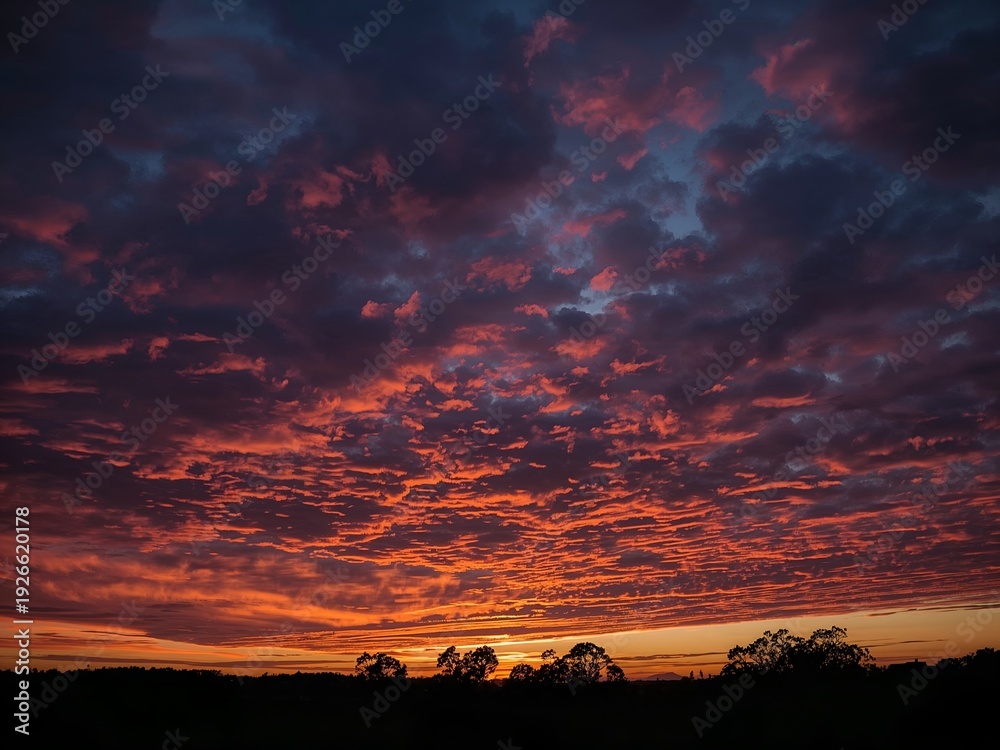 Obraz premium Fiery sunset with vibrant colors across the sky, offering a stunning and dramatic view 