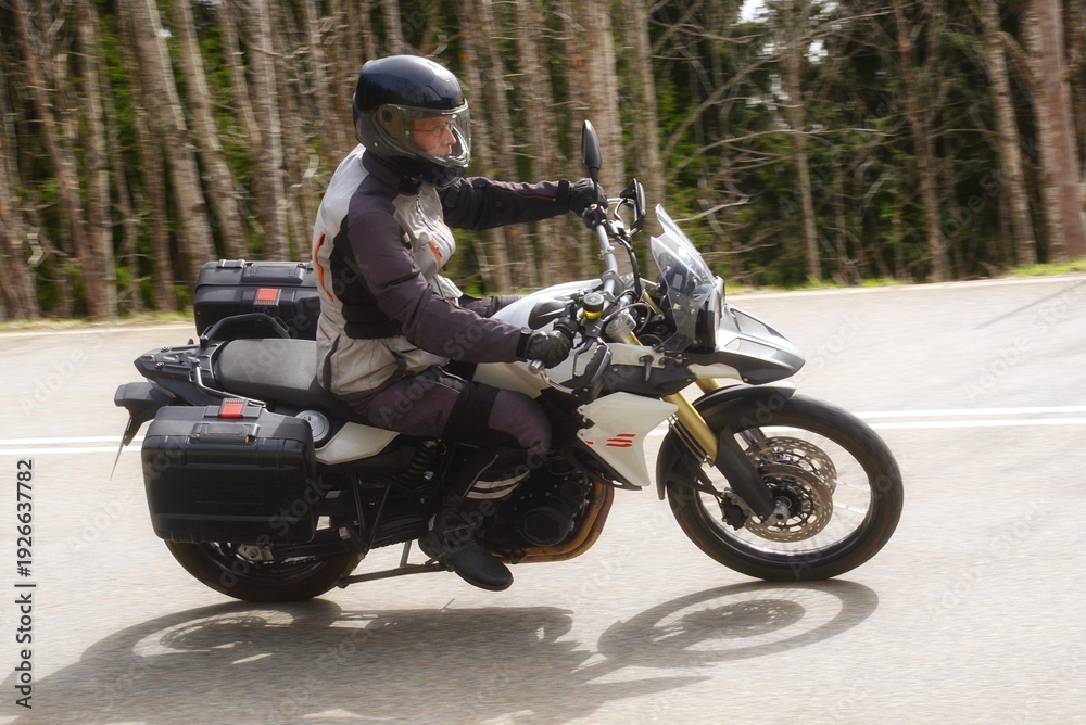 Fototapeta premium Motorradfahrer auf einer Landstrasse in einer Kurve beim dynamischen fahren