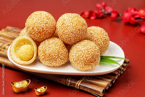 Fotografie Traditional Chinese New Year snack onde-onde (sesame balls) served on a red festive background with gold decorations