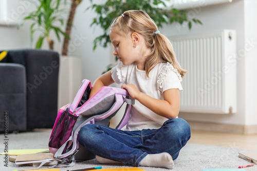 Little Girl Packing Backpack at Home. Back to school