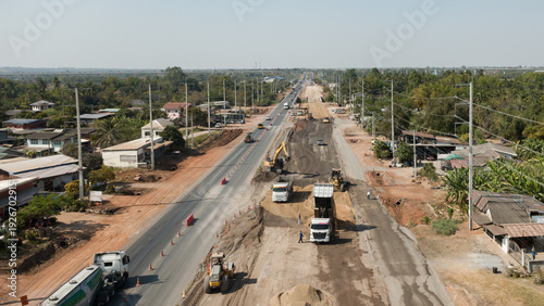 Φωτογραφία Aerial view of road construction with heavy machinery and trucks upgrading highway infrastructure in rural area, symbolizing development and economic growth
