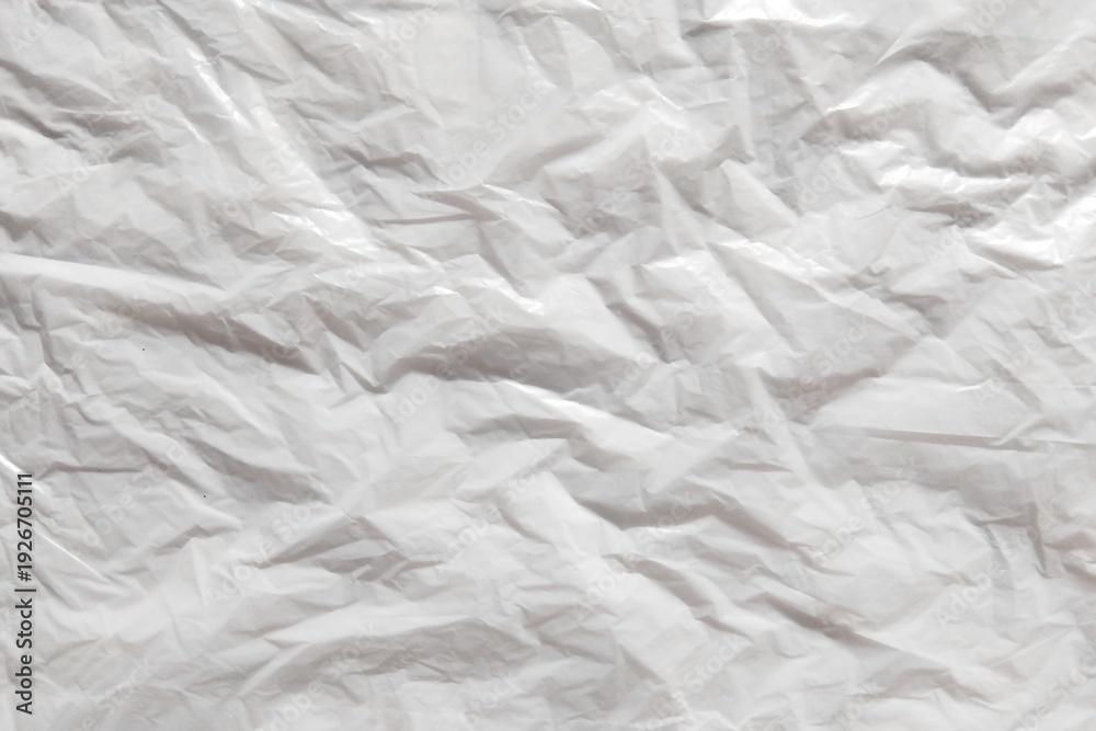 Fototapeta premium ​Crumpled white plastic texture background, wrinkled synthetic film surface