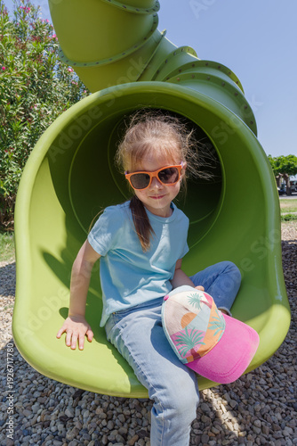 Girl having fun in tube slide on playground