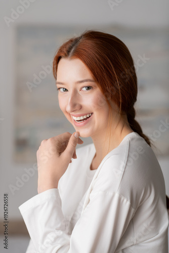 Free Download Young woman with red hair enjoys a peaceful moment at home in her stylish apartment - GFXLoad