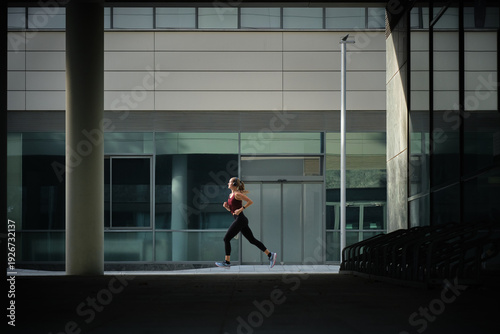 Schilderij op canvas side view of Woman doing daily running in urban barcelona