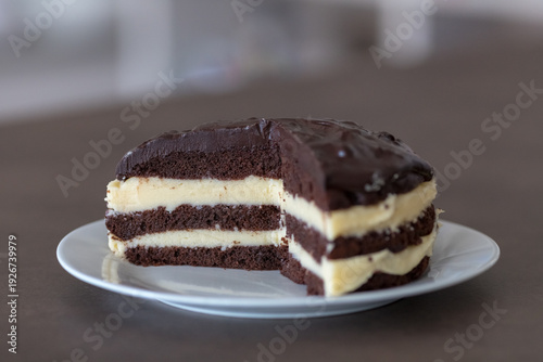 Homemade Chocolate Layer Cake with White Cream Filling and Glaze on a Plate.