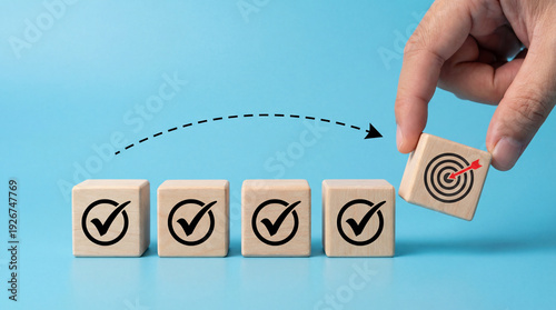Hand placing target block on checklist, achieving goals, business success, strategy, planning