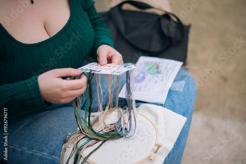 Woman's hands choosing embroidery thread colors