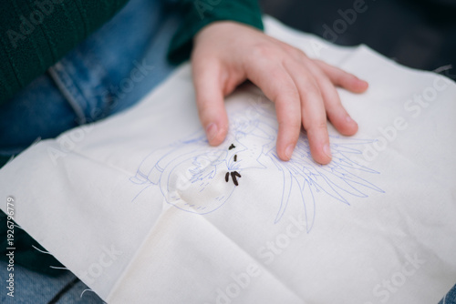 Vászonkép Person embroidering a design onto white fabric