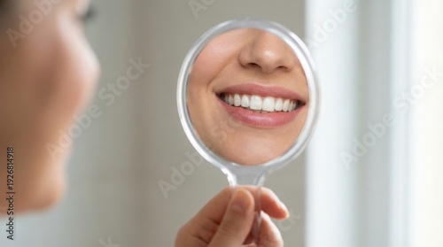 Woman smiling and examining her white teeth in a handheld mirror, dental care, oral hygiene, self-care, healthy lifestyle.