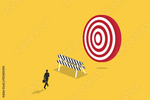 Businessman walking toward a giant target behind a road barrier, representing goal setting, overcoming obstacles, and professional performance success