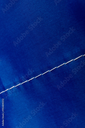 Seams on nylon fabric with stitches. Synthetic fabric texture. Macro detail.