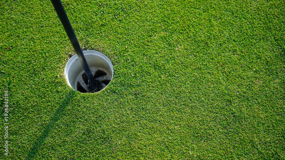 Obraz premium Golf hole is on a green lawn in a beautiful golf course.