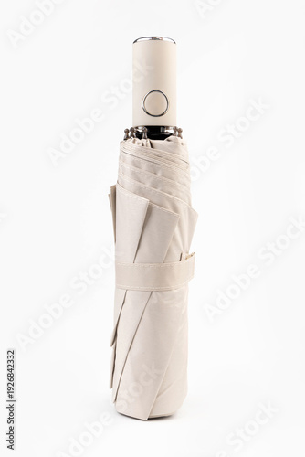 Folded biege automatic umbrella isolated on white background