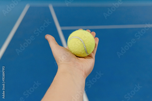tennis ball in man hand, indoor tennis court, POV view, copy space