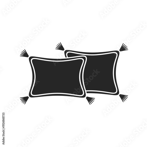Two black cushions with white trim and tassels on a white background
